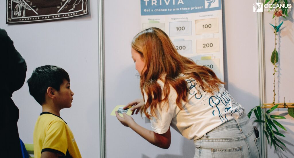 A young kid joining our trivia game during the asian bird fair